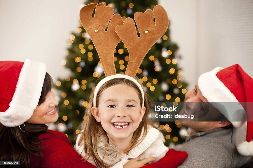 Śmiać się rodziny w rogi i Santa kapelusze z Christmas Tree - Zbiór zdjęć royalty-free (Boże Narodzenie)