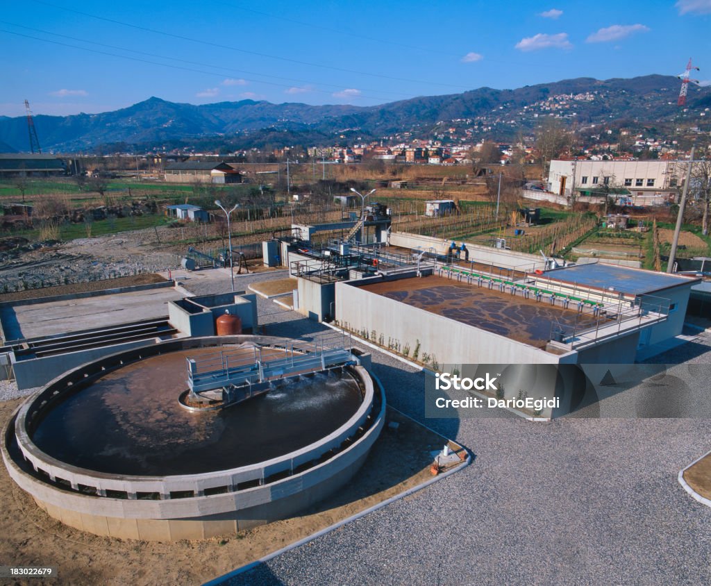 Liquami treatmen stabilimento industriale con paesaggio sullo sfondo, aereal vista - Foto stock royalty-free di Impianto di depurazione dell'acqua