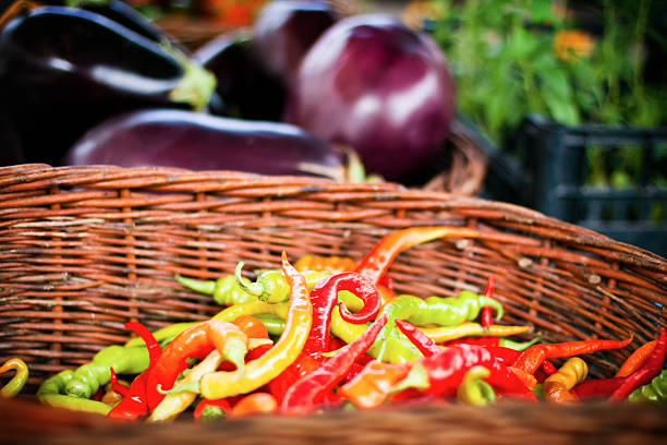 Basket with Peppers and eggplants in the background
