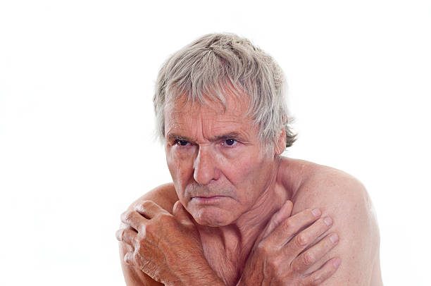 Shivering serious senior man naked shoulders stock photo