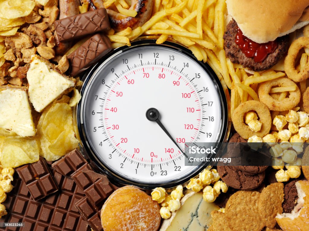 体重計に高カロリー食品 - 食べ物のロイヤリティフリーストックフォト