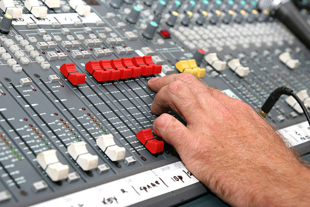 Good Sound Selective focus on a sound mixers hand with bright LEDs regler stock pictures, royalty-free photos & images