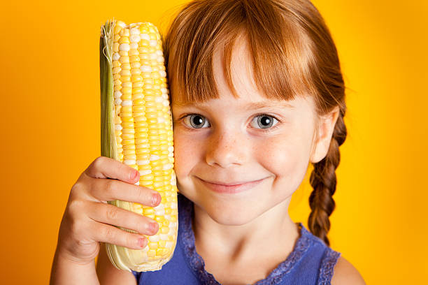 istock Happy Red-Haired Girl Holding Corn on the Cob 183023472