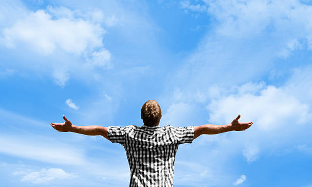 istock Man with outstretched arms looking up to sky 183023480