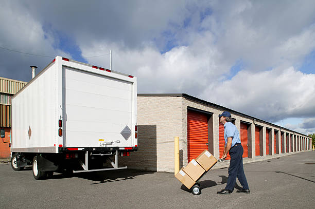 istock Delivery man taking boxes to the truck on a dolly 183024445