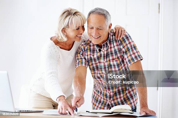 Smiling Mature Couple With Book Map And Laptop Stock Photo - Download Image Now - 40-49 Years, 50-59 Years, Active Seniors