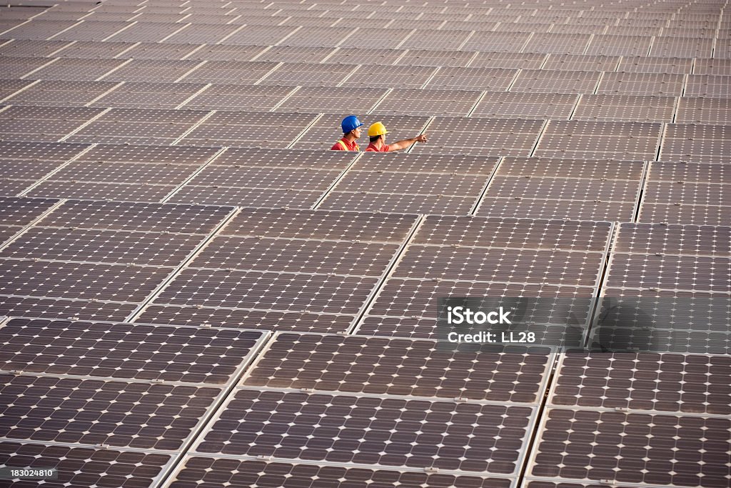 Two engineers working on solar panels Image of two engineers examining the condition of photovoltaic farm (ISO 100). All my images have been processed in 16 Bits and transfer down to 8 before uploading. Solar Power Station Stock Photo