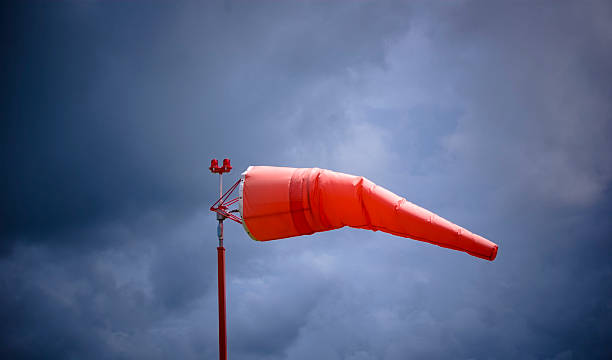 stormy weather windsock airport windsock bright orange  against sky. gale stock pictures, royalty-free photos & images