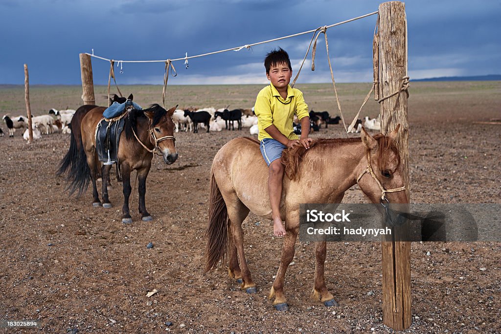 Mongolian boy with horse Mongolian boy with horse, cloudy sky in the background.http://bem.2be.pl/IS/mongolia_380.jpg Gobi Desert Stock Photo