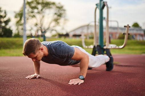 Young athlete doing push-ups outdoors