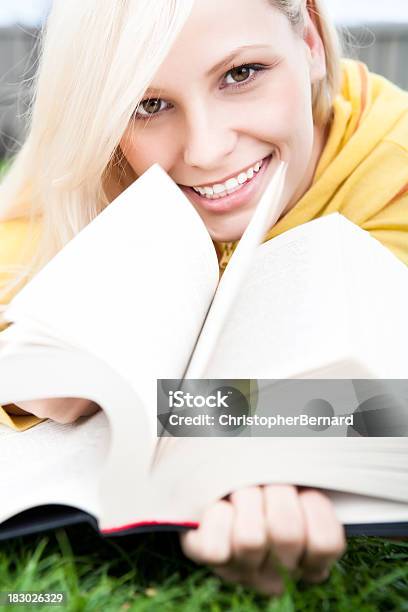 Smiling Female Student Reading Lying On Grass Stock Photo - Download Image Now - 20-24 Years, Adult, Adults Only