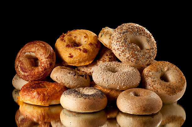 Pile of assorted bagels on reflective surface