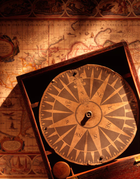 papel antigo bússola sobre fundo de mapa antigo - compass direction antique guidance imagens e fotografias de stock
