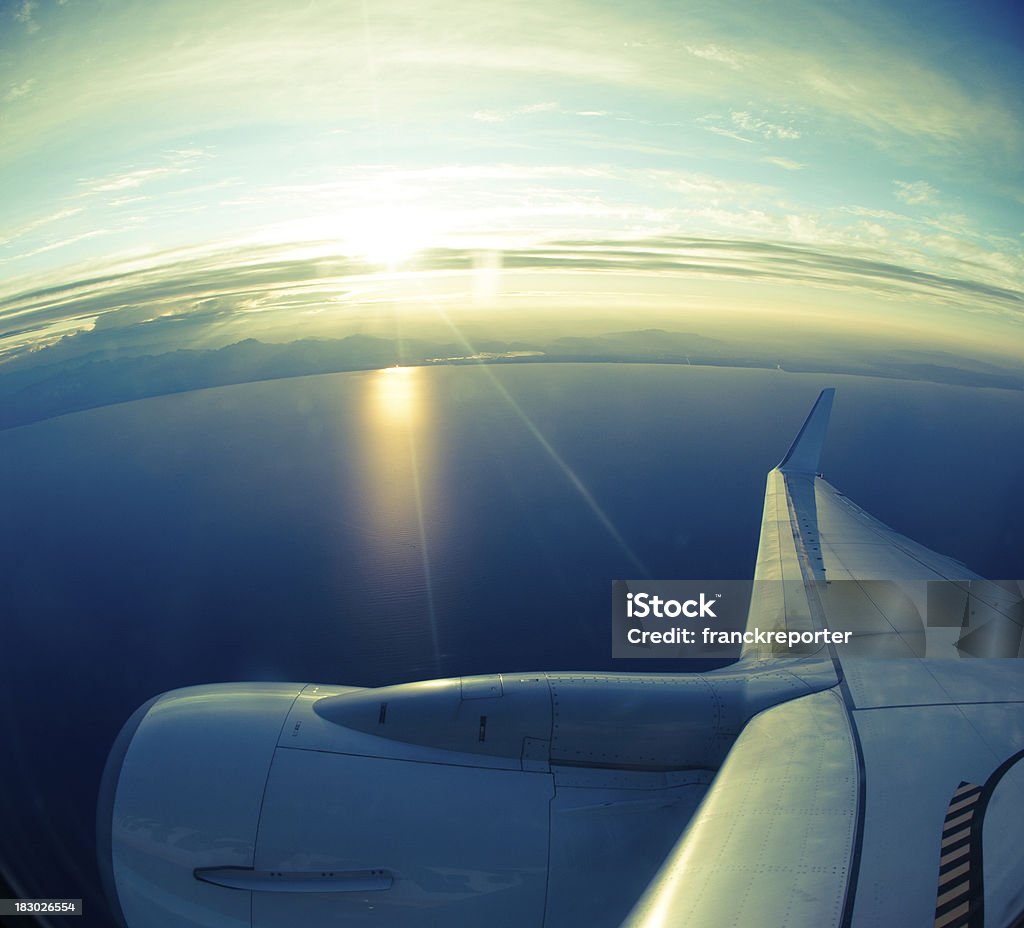 Vista desde avión adornos de la costa del mar en la puesta de sol - Foto de stock de Ala de avión libre de derechos
