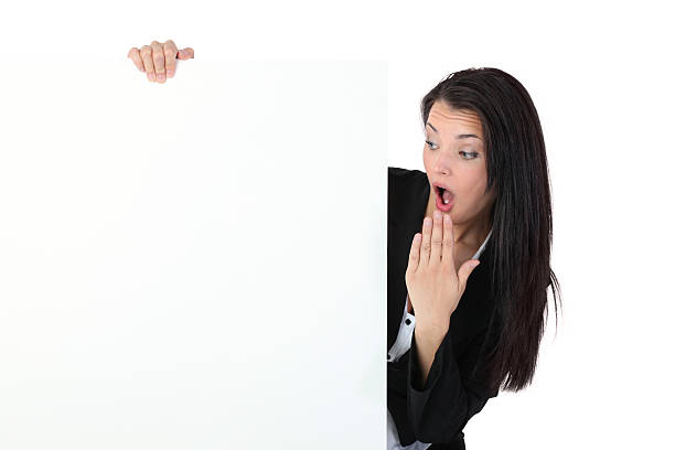 mujer de negocios mirando en un cartel con sorpresa - businesswoman advertise placard advertisement fotografías e imágenes de stock