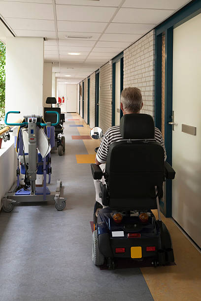 Senior citizen equitazione scooter di mobilità, pensionamento casa corridoio (XL - foto stock