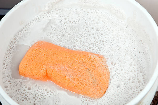 Directly above photo of metal kitchen sink full with dirty dishes, foam and water