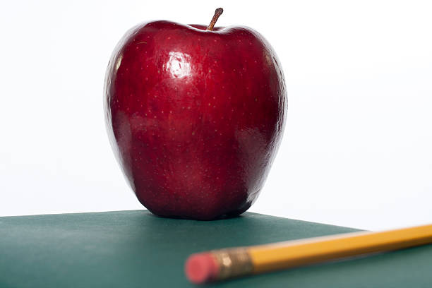 Pencil and Apple on Schoolbook stock photo