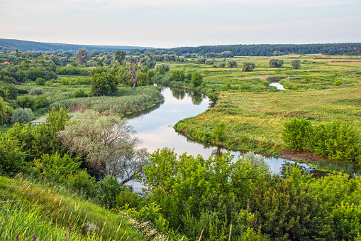 Picturesque landscape of the Seversky Donets river valley with meadow and trees in the countryside. View from the hill to the Siversky Donets River