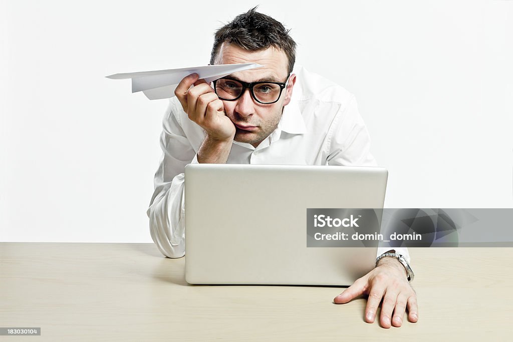 Empleada de oficina con ordenador portátil y libro de avión es aburrido - Foto de stock de Fondo blanco libre de derechos