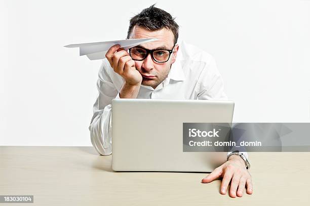 Empleada De Oficina Con Ordenador Portátil Y Libro De Avión Es Aburrido Foto de stock y más banco de imágenes de Fondo blanco