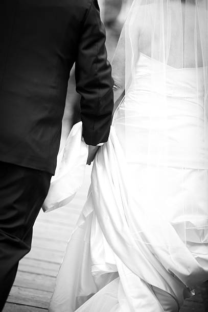 istock Bride and Groom Walking Away on Scenic Bridge 183030174