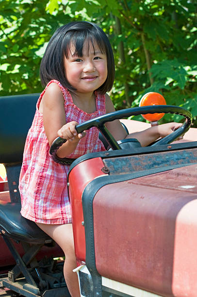 Little girl playing on tractor.