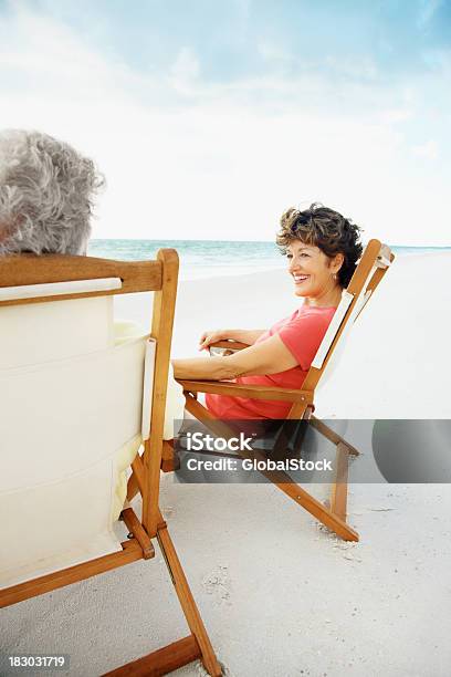 Relaxed Smiling Mature Couple Enjoying Their Vacation On Beach Stock Photo - Download Image Now