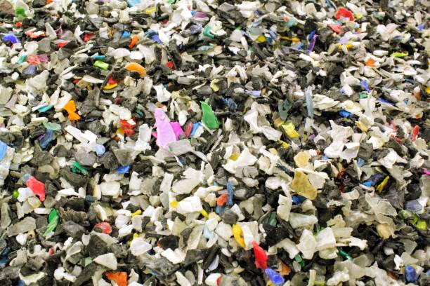 istock Shredded plastic pieces prepare for recycling. Raw cables material for reproduction. Sorting garbage on waste plant. Pile of scrap bottles on trash storage factory. Environmental concept 1830319011