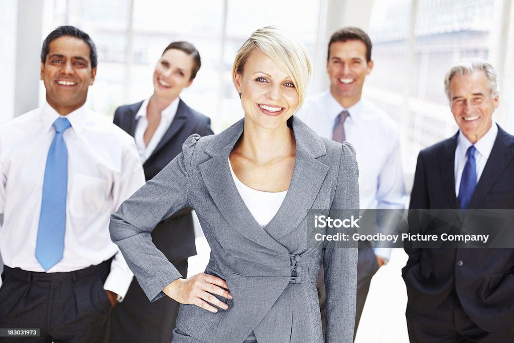 Feliz medio de mujer de negocios y su equipo en fondo - Foto de stock de 40-49 años libre de derechos