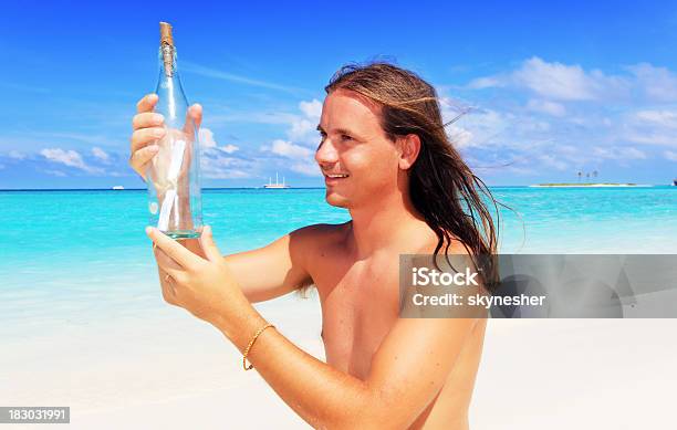 Hombre Planteado Una Botella Con Mensaje Foto de stock y más banco de imágenes de Botella - Botella, Encontrar, Playa
