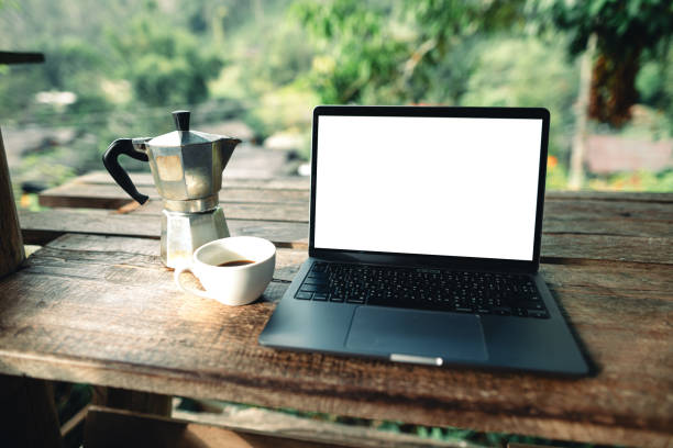 istock Laptop on table with coffee and stock graphs 1830324566