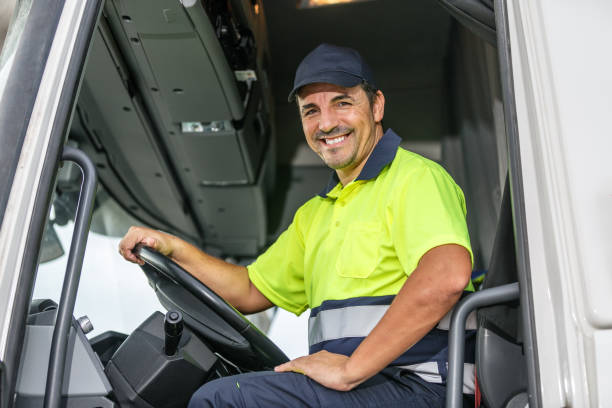istock Cheerful male driver sitting in truck while looking at camera 1830327293
