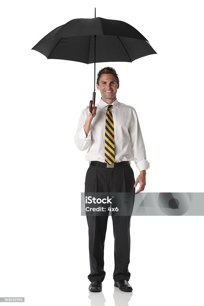 Uomo d'affari tenendo un ombrello - Foto stock royalty-free di Abbigliamento elegante