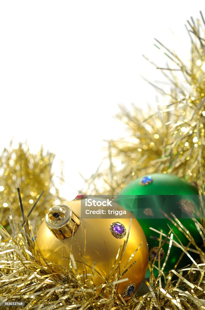 Christmas decorations in gold tinsel Gold and green christmas decorations on gold tinsel, isolated on white Celebration Event Stock Photo