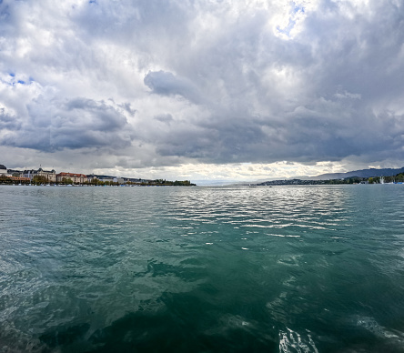 View of lake Zurich with moody sky and cityscape from a tour boat in Switzerland.