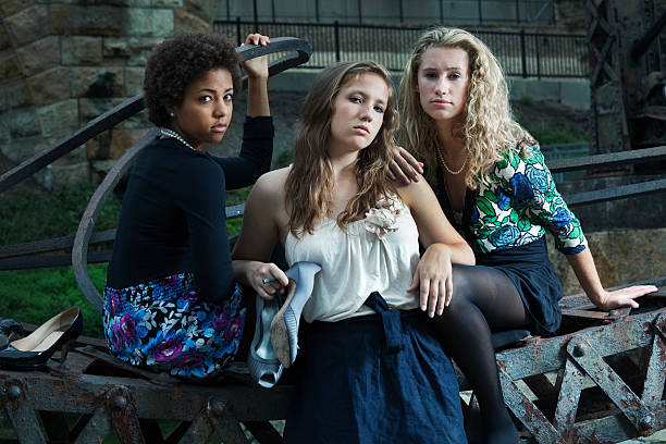 3 つの若い女性や少女に立つ産業遺跡 - women leaning fashion wall ストックフォトと画像