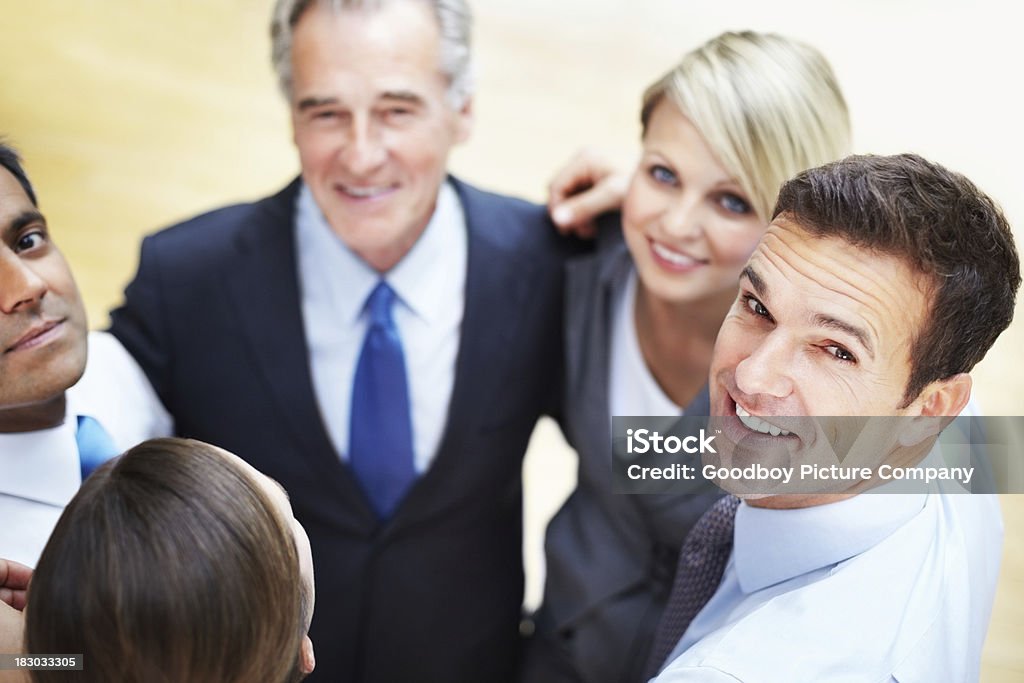 Hombre de negocios con equipo de pie en huddle mirando a usted - Foto de stock de 40-49 años libre de derechos