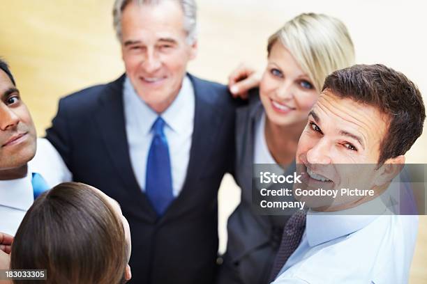 Hombre De Negocios Con Equipo De Pie En Huddle Mirando A Usted Foto de stock y más banco de imágenes de 40-49 años