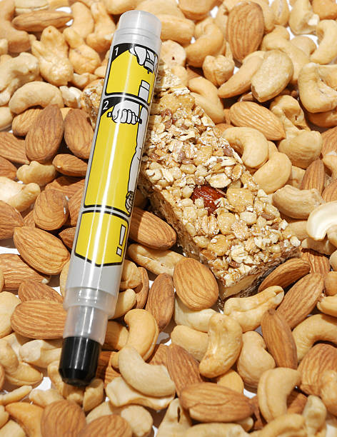 Epipen for allergy. Epipen for allergy over nuts and granola bar. adrenaline stock pictures, royalty-free photos & images