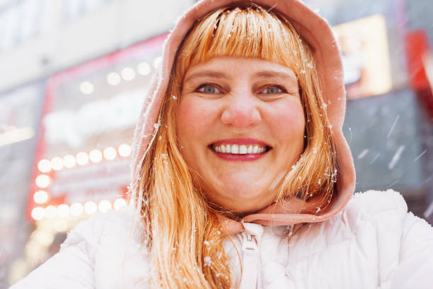 istock Portrait positive middle-aged woman enjoying snowfall 1830337069