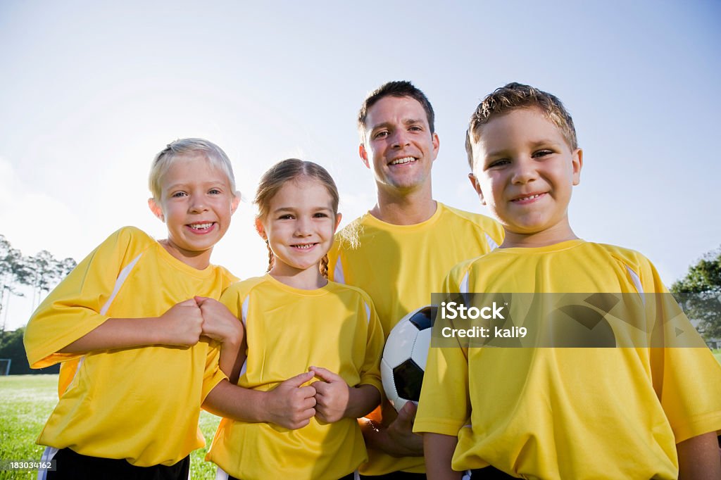 Entrenador de fútbol con pelota y equipo de niños pequeños - Foto de stock de Fútbol libre de derechos