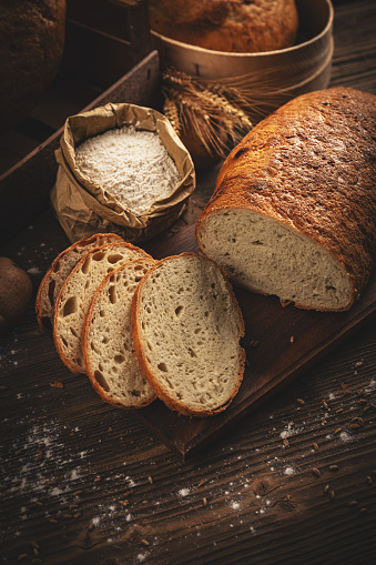 Concept of traditional sourdough bread on dark wooden background