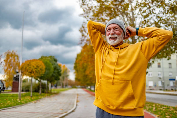 istock Smiling senior man doing stretching in public park. 1830344185