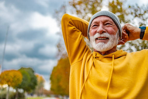 istock Handsome senior man standing alone outside and stretching before going for a run. 1830344716