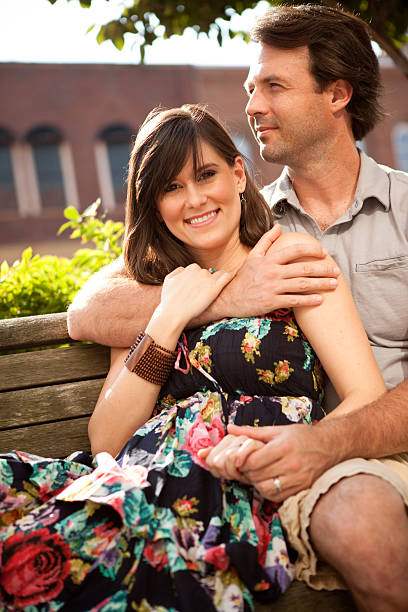 istock Happy Young Couple Cuddling on Bench Downtown 183034717