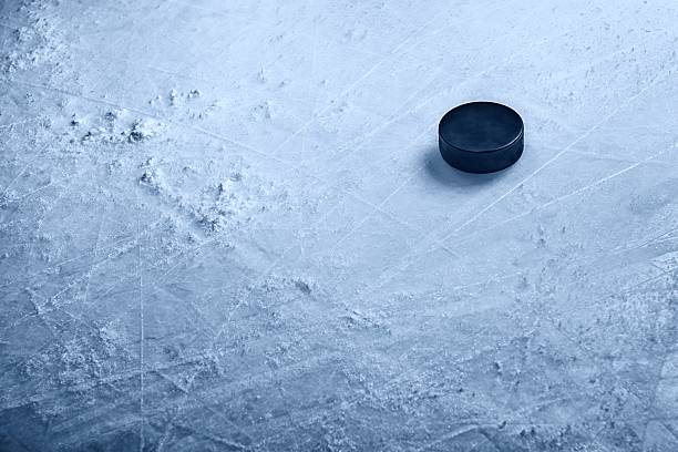 Hockey Puck on Ice A hockey puck on textured ice with ample space for copy.Click on an hockey puck photos stock pictures, royalty-free photos & images