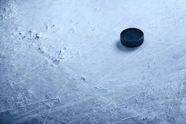 A hockey puck on textured ice with ample space for copy.Click on an