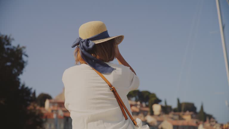 SLO MO Stylish Pose: Woman Adorns Rovinj's Promenade with Elegance, She Looks Back at the Camera with Smile on Her Face