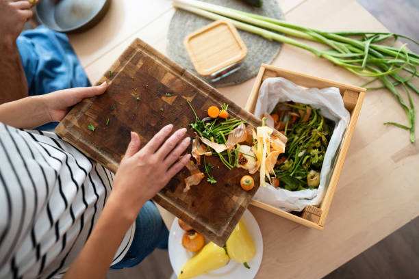 istock Unrecognizable woman Japanese ethnicity using vegetable leftovers for a compost 1830353438